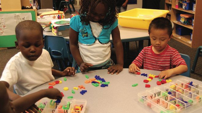 学生们在教室桌子上玩塑料字母